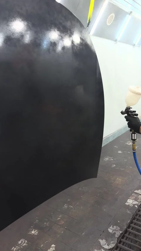 Professional auto body painter applying black primer with spray gun in booth Stock Footage 341134687