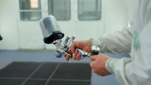 Professional auto body technician test spray gun inside a clean, well lit 스톡 동영상 321516178
