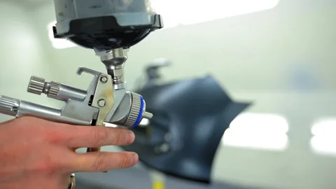 Professional auto body technician tests spray gun before painting inside a clean Stock Footage 321665891