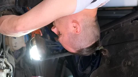 A professional auto mechanic changes engine oil in an engine at a bus station Stock-Footage 250026875