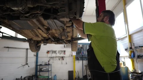 Professional auto mechanic in uniform repairs detail of car using wrench tool Stock Footage 326044457