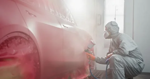 Professional Auto Painter Applying Red Paint in Spray Booth Stock Footage 276606248