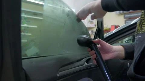 Professional auto service worker using a handheld steam cleaner to carefully Vídeos de archivo 337537887