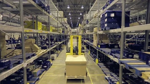 Professional autoloader operator transporting box between racks in storage Video stock 61136273