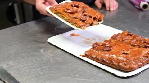 Professional baker cutting and serving a slice of galician empanada Stock Footage 330428685