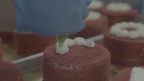 Professional baker decorating red velvet cake with white frosting Vídeos de archivo 327358191