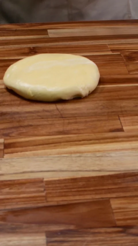 Professional Baker Flattening Enriched Dough with Wooden Rolling Pin Stock Footage 328986917