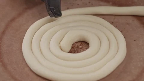 Professional baker forms the dough into a snail shape before baking. Stock Footage 313981447