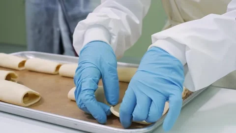 Professional Baker Hands Rolling Fresh Dough for Apple Hand Pies in Commercial B Stock Footage 337751406