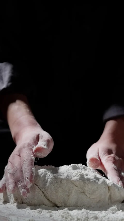 Professional baker kneading dough with rhythmic hands, creating smooth elastic Stock Footage 301646916