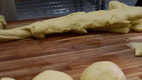 Professional Baker Portioning Fresh Dough with Bench Scraper on Wood Table Stock Footage 327716034