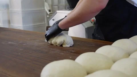 Professional baker preparing bread mixing, kneading, and shaping dough by hand Video stock 313535719