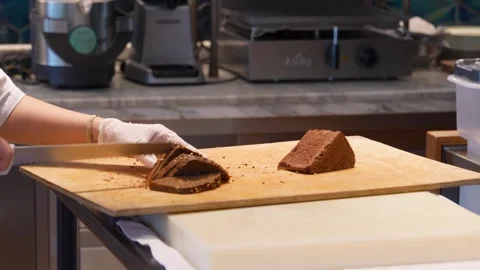 Professional Baker Slicing Dark Rye Bread with Seeds. Chef slicing a triang.. Video stock 331213603