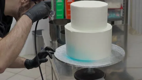 Professional baker using edible airbrush colours to decorate two floor laye.. Stock Footage 228181015