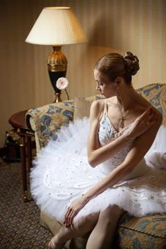 Professional ballet dancer sitting on sofa Stock Photos