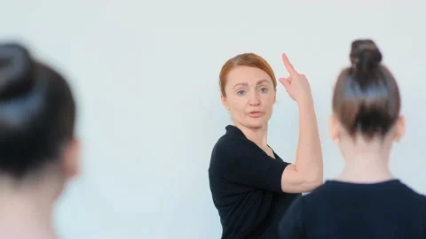 Professional ballet teacher explains dance moves to girls 库存影片 134251220