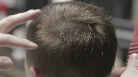 Professional barber cut light-brown hair of his client with scissors Stock Footage 89665745