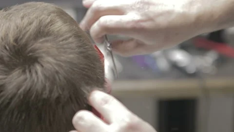 Professional barber cut light-brown hair of his model with scissors Stock Footage 89667986
