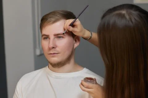 Professional barber doing threading procedure and correcting shape of eyebrows Stock Photos