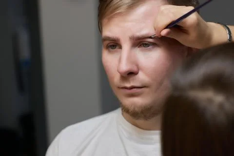 Professional barber doing threading procedure and correcting shape of eyebrows Stock Photos