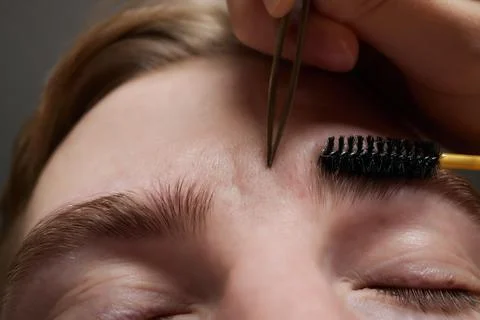 Professional barber doing threading procedure and correcting shape of eyebrows Stock Photos