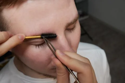 Professional barber doing threading procedure and correcting shape of eyebrows Stock Photos