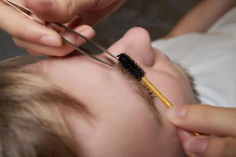Professional barber doing threading procedure and correcting shape of eyebrows Stock Photos