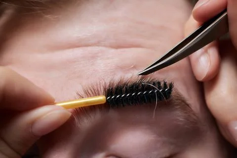 Professional barber doing threading procedure and correcting shape of eyebrows Stock Photos