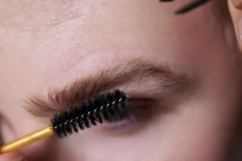 Professional barber doing threading procedure and correcting shape of eyebrows Stock Photos