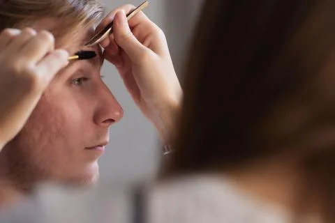 Professional barber doing threading procedure and correcting shape of eyebrows Stock Photos