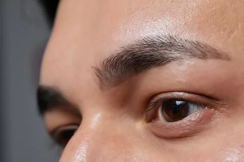 Professional barber doing threading procedure and correcting shape of eyebrows Stock Photos