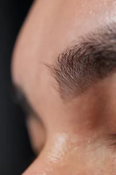 Professional barber doing threading procedure and correcting shape of eyebrows Stock Photos