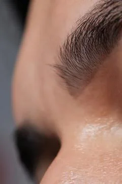Professional barber doing threading procedure and correcting shape of eyebrows Stock Photos