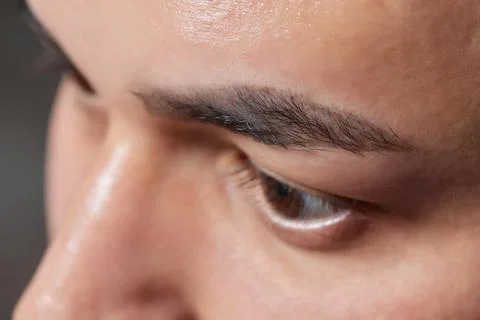 Professional barber doing threading procedure and correcting shape of eyebrows Stock Photos