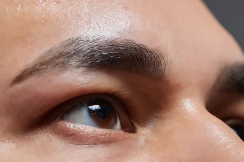 Professional barber doing threading procedure and correcting shape of eyebrows Stock Photos