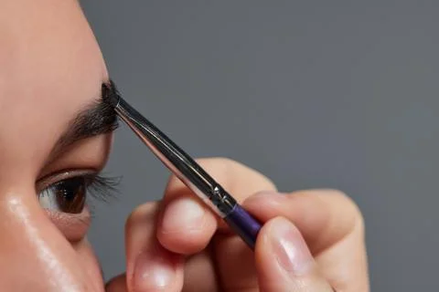 Professional barber doing threading procedure and correcting shape of eyebrows Stock Photos