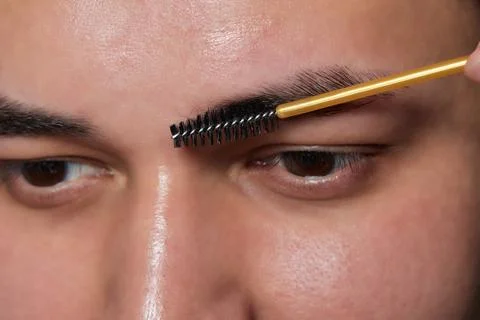 Professional barber doing threading procedure and correcting shape of eyebrows Stock Photos