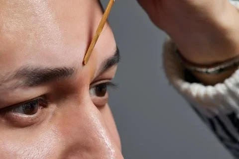 Professional barber doing threading procedure and correcting shape of eyebrows Stock Photos