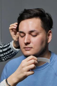 Professional barber doing threading procedure and correcting shape of eyebrows Stock Photos