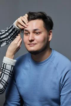 Professional barber doing threading procedure and correcting shape of eyebrows Stock Photos