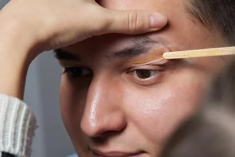 Professional barber doing threading procedure and correcting shape of eyebrows Stock Photos