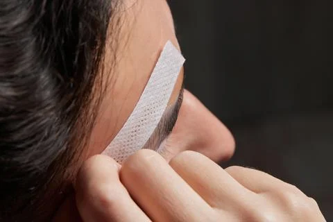 Professional barber doing threading procedure and correcting shape of eyebrows Stock Photos