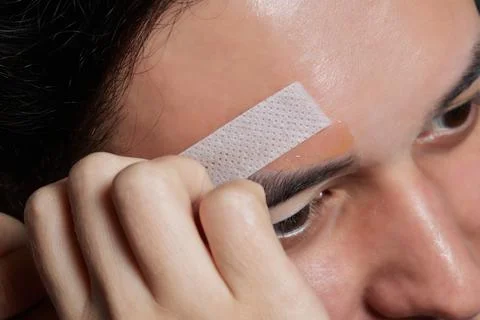 Professional barber doing threading procedure and correcting shape of eyebrows Stock Photos