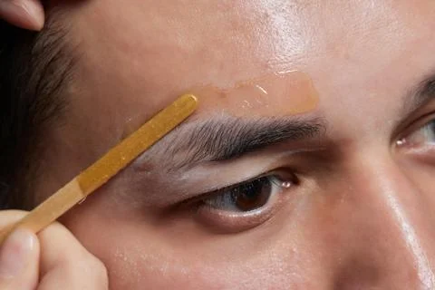 Professional barber doing threading procedure and correcting shape of eyebrows Stock Photos