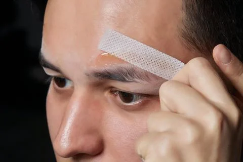 Professional barber doing threading procedure and correcting shape of eyebrows Stock Photos