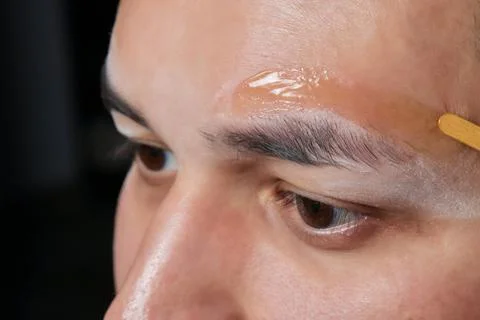 Professional barber doing threading procedure and correcting shape of eyebrows Stock Photos