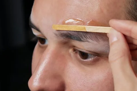 Professional barber doing threading procedure and correcting shape of eyebrows Stock Photos