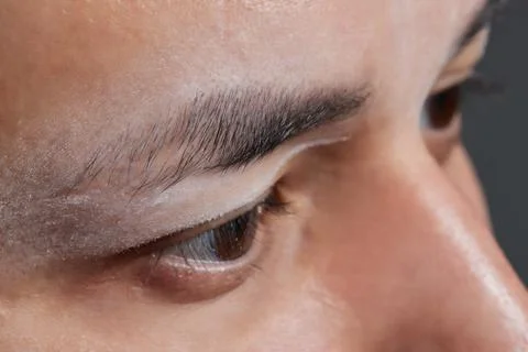 Professional barber doing threading procedure and correcting shape of eyebrows Stock Photos