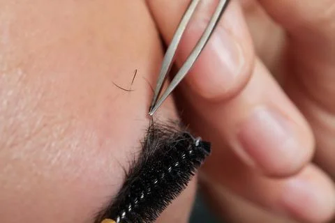 Professional barber doing threading procedure and correcting shape of eyebrows Stock Photos