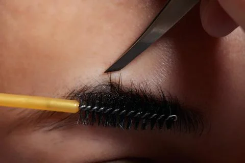 Professional barber doing threading procedure and correcting shape of eyebrows Stock Photos